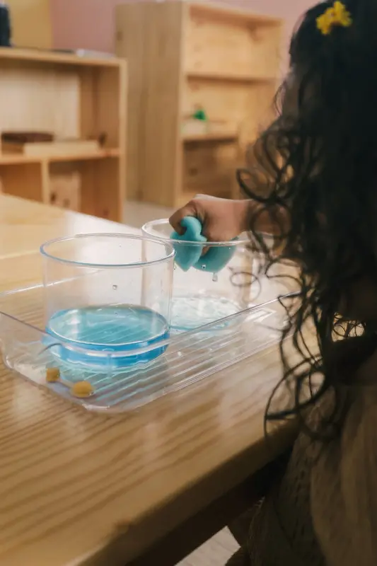 Niña haciendo una actividad de trasvase de agua con esponja